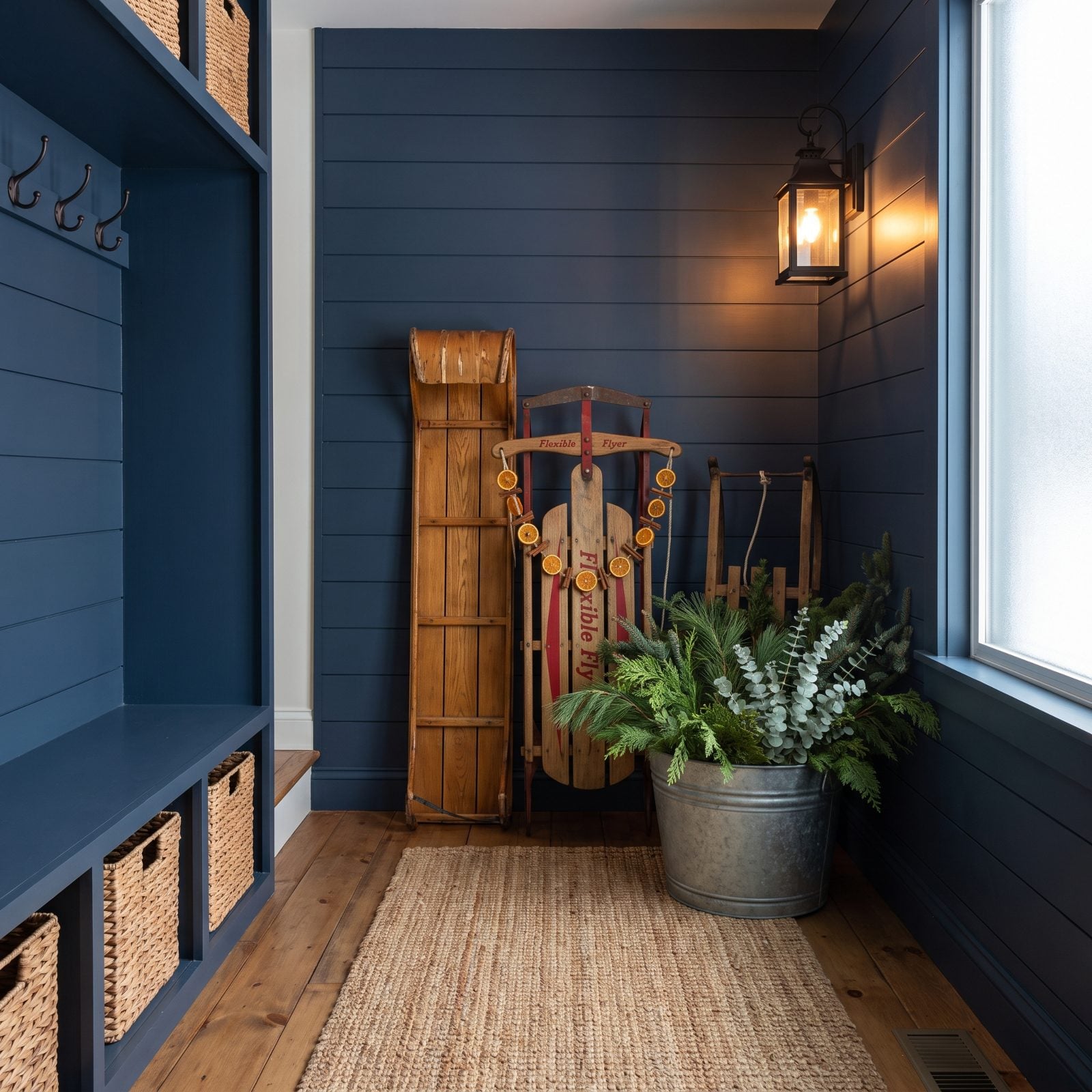 A Collection of Antique Sleds and Winter Greenery