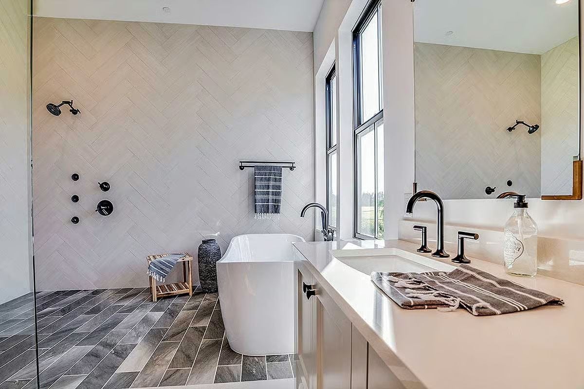 Herringbone Tile, a Freestanding Tub, and Matte Black Fixtures That Earn Their Keep