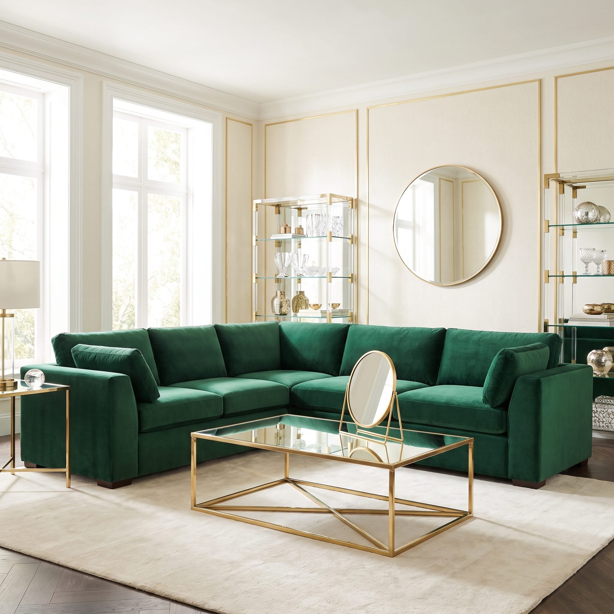 Plum velvet sofa and two cream chairs around a small round metal table with a small mirror above the sofa.