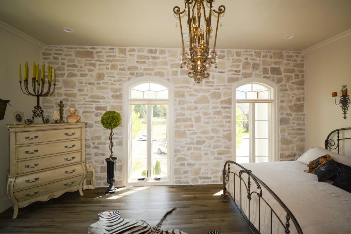 Raw Stone Wall with Arched French Doors That Pull the Outside In
