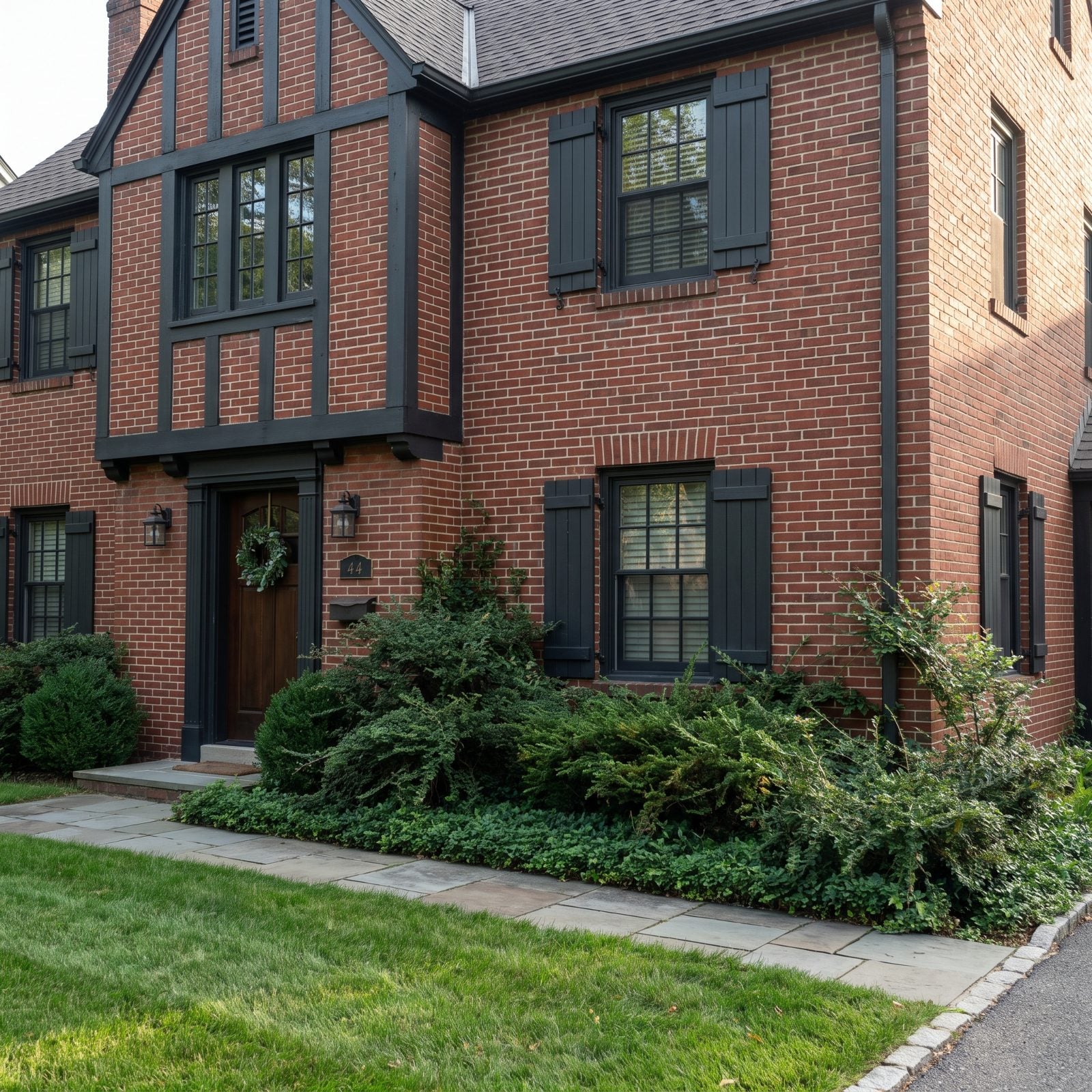 Red brick traditional home with an eighteen-inch-deep foundation bed where shrubs have outgrown the space and press against