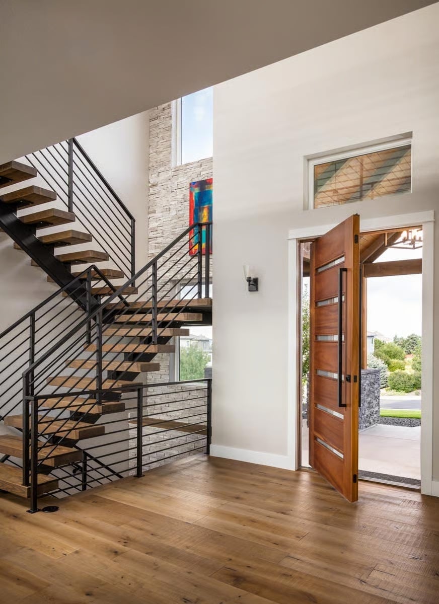 Floating Staircase and Pivot Door Set the Tone Before You're Even Inside