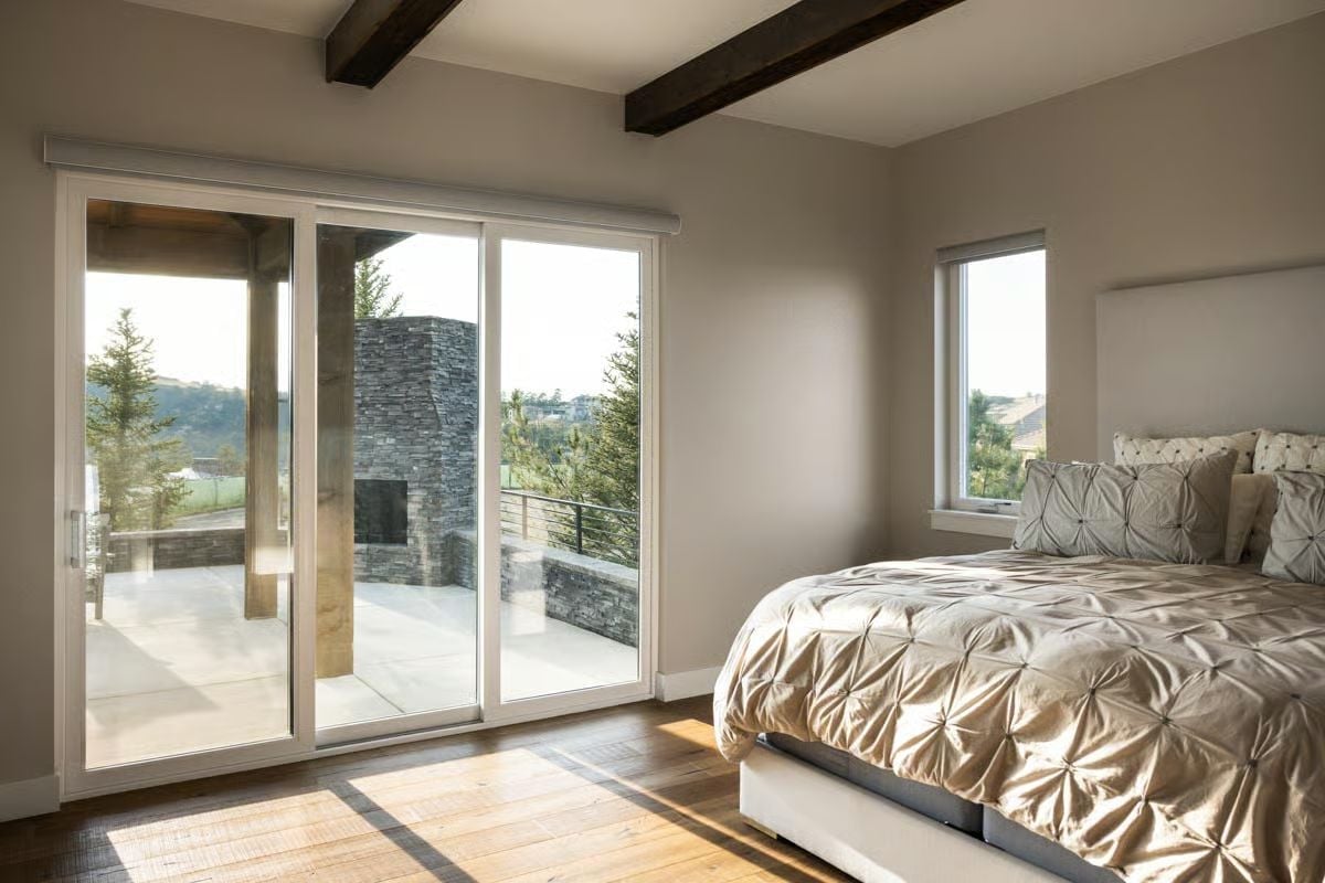 Sliding Glass Panels Open the Primary Bedroom Straight Onto a Stone Terrace