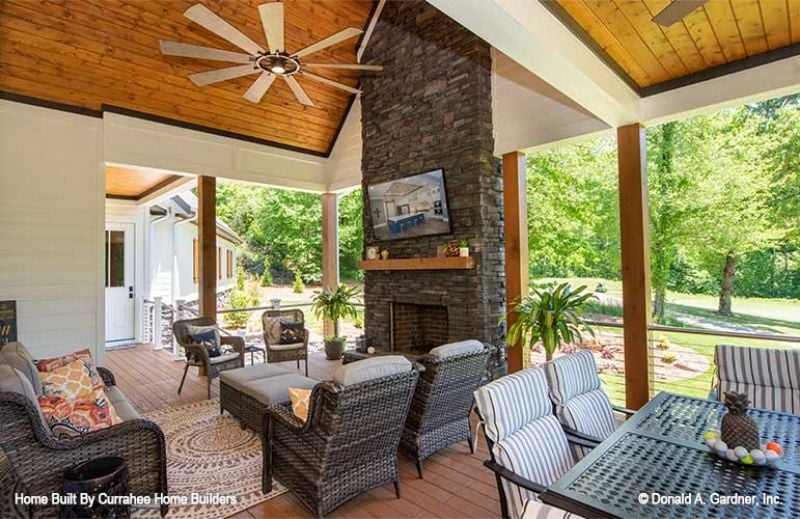 Covered Porch Stone Fireplace With a Ceiling Fan That Means Business