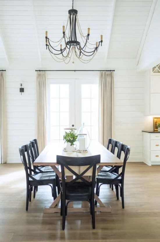 Black X-Back Chairs Around a Farmhouse Trestle Pull the Whole Room Together