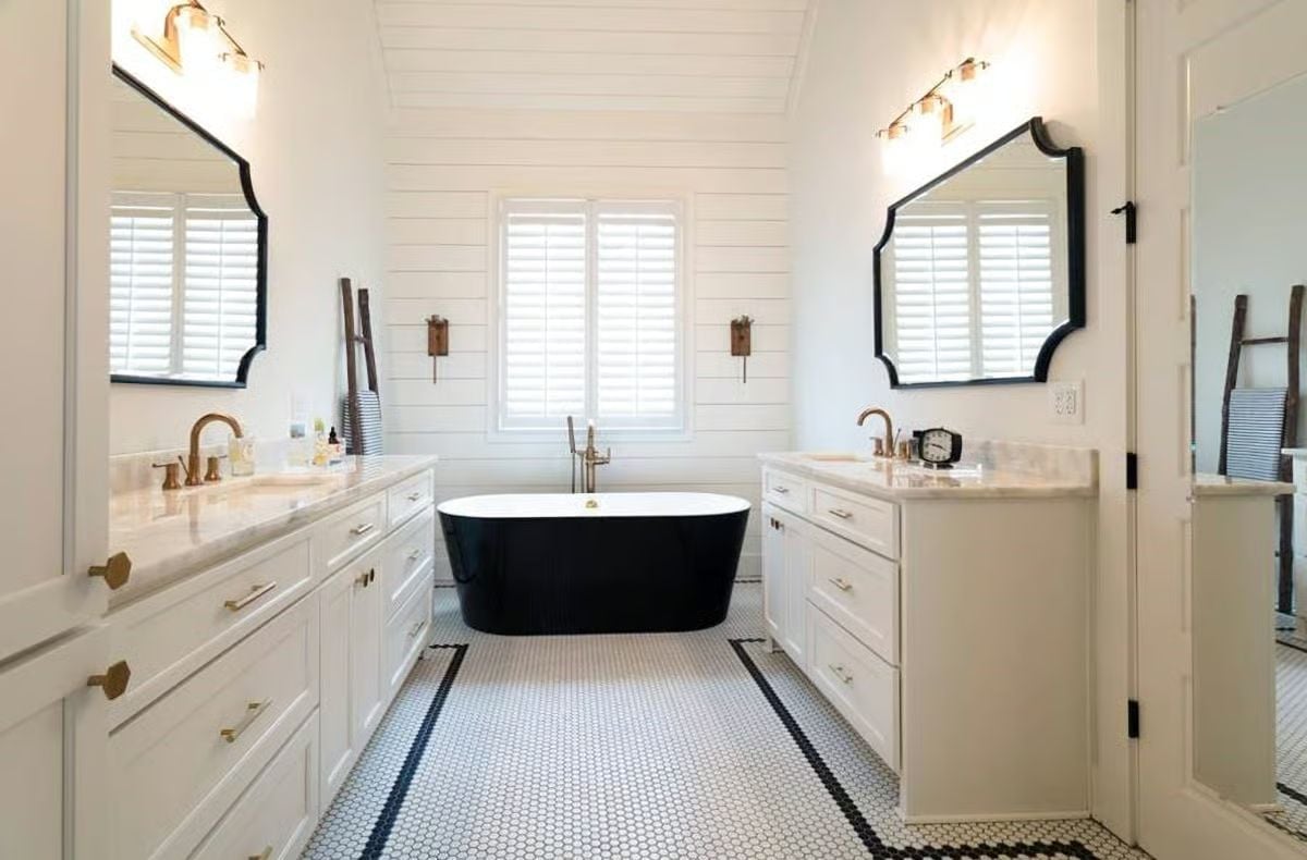 Freestanding Black Tub Centered Between Two Vanities That Each Have Their Own Mirror