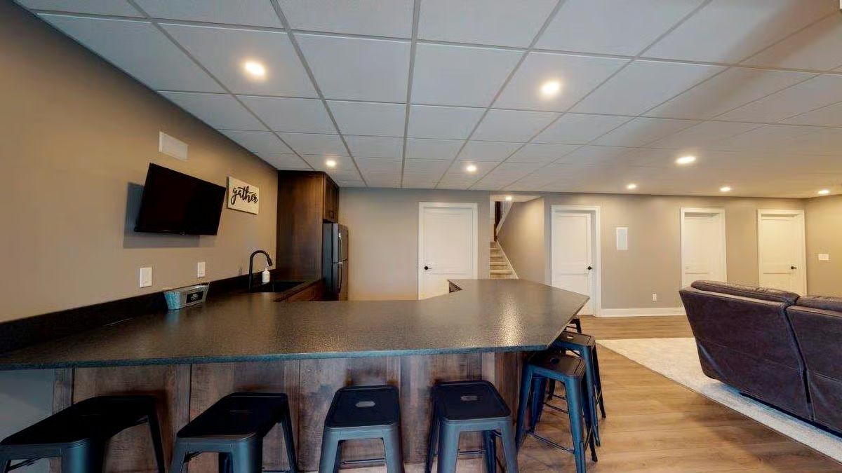Basement Bar With Dark Counters and Enough Seating to Mean It