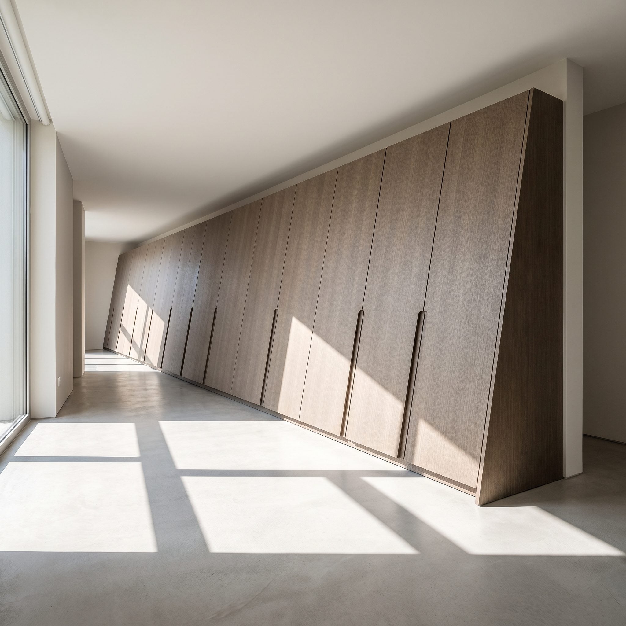 Bedroom with champagne-colored wardrobes following a diagonal wall beside a rounded taupe bed