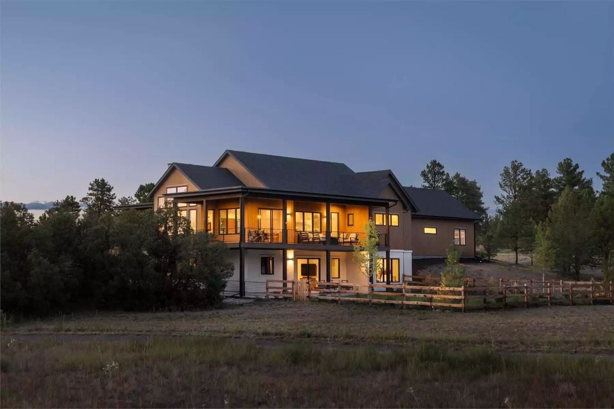 Warm Light Spills Out Across Open Grassland From a House That Earned Its Setting
