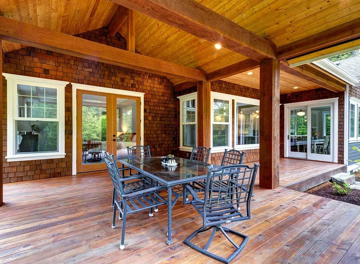 Covered Porch Dining With Cedar Walls and Timber Beams Overhead