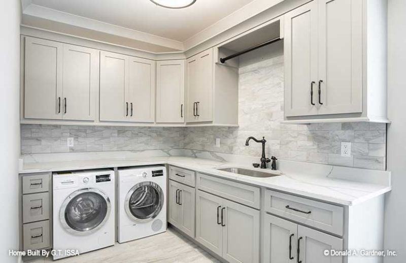 Marble Tile Backsplash and a Hanging Rod That Make Laundry Feel Less Like a Chore