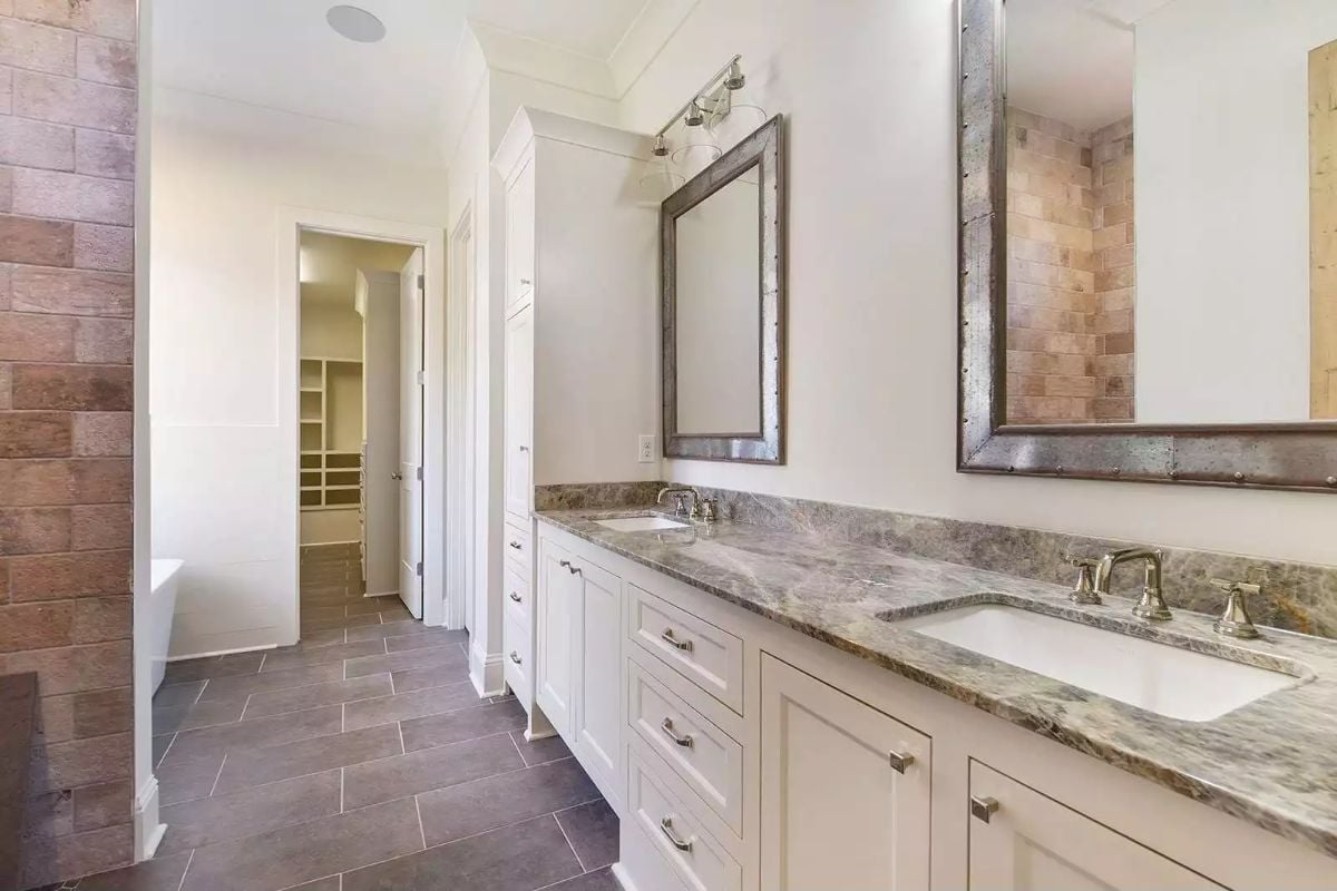 Marble Counters, Rustic Mirror Frames, and a Walk-In Closet Visible Through the Door