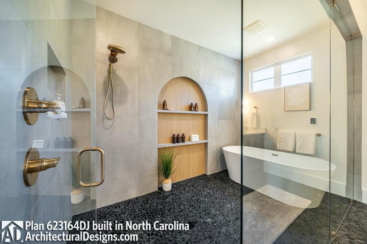 Arched Niche With Fluted Wood Shelving Inside a Glass-Enclosed Shower