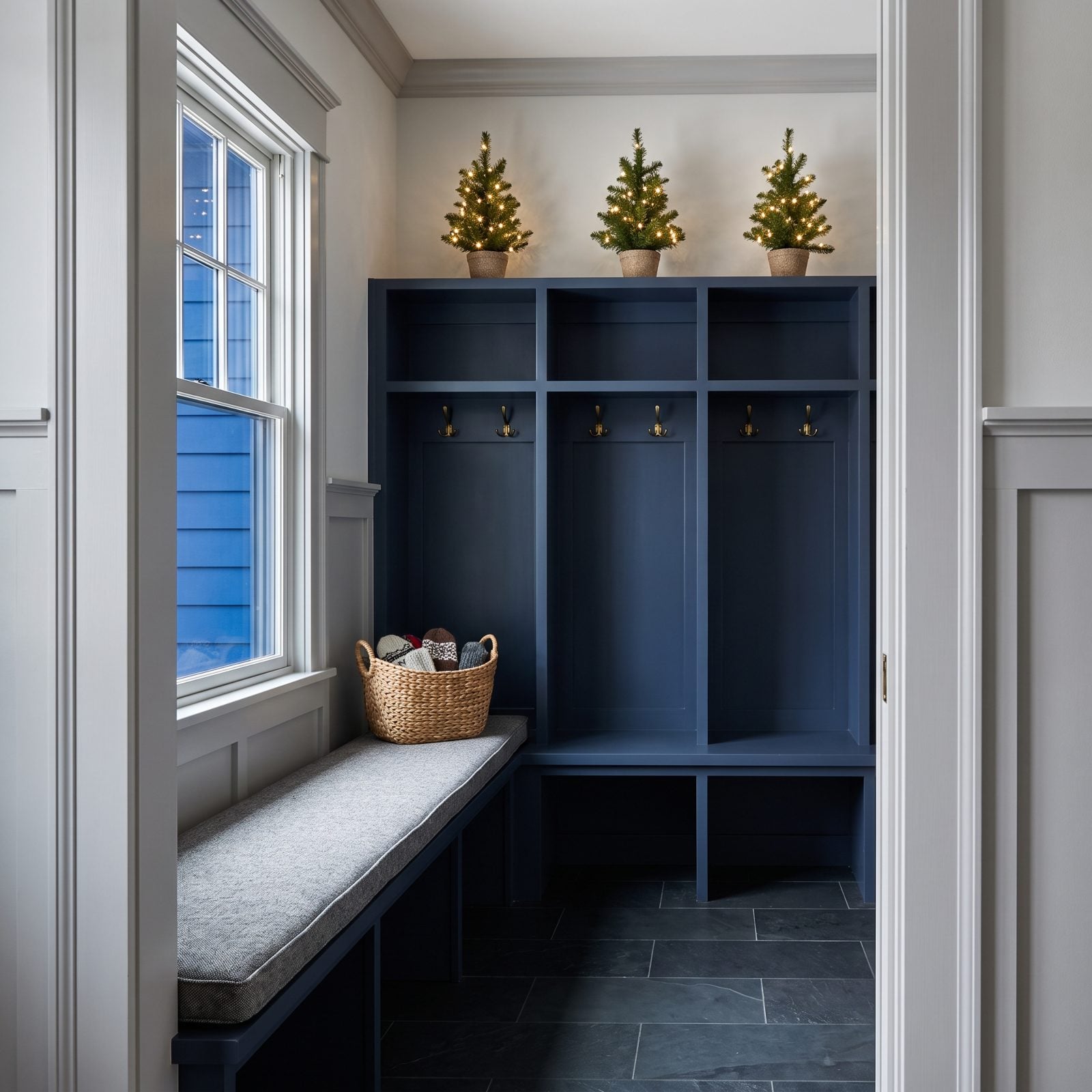 A Mudroom with Lighted Miniature Trees Above the Lockers