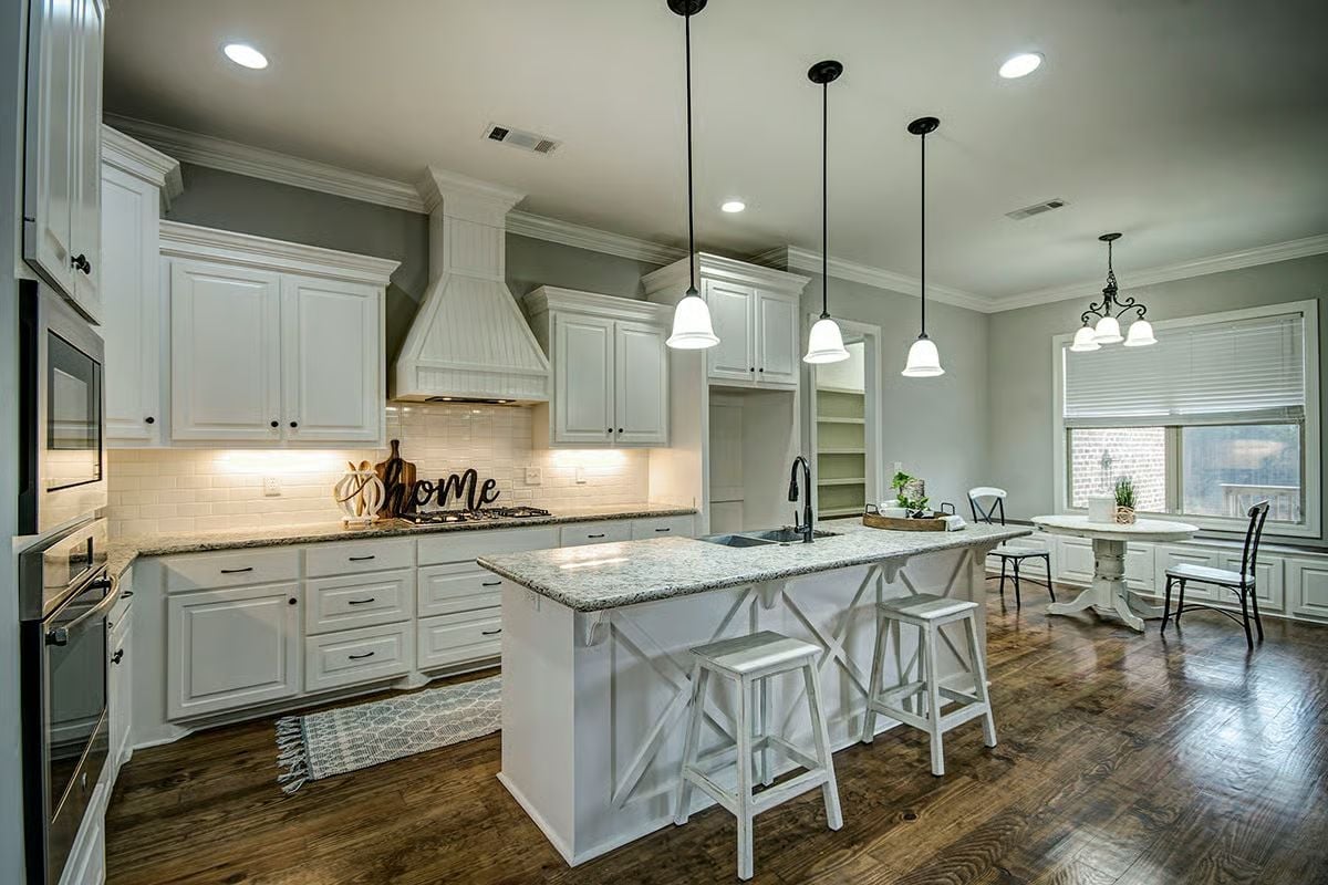 Granite Island and Bell Pendants Make This Kitchen the House's Natural Gathering Spot
