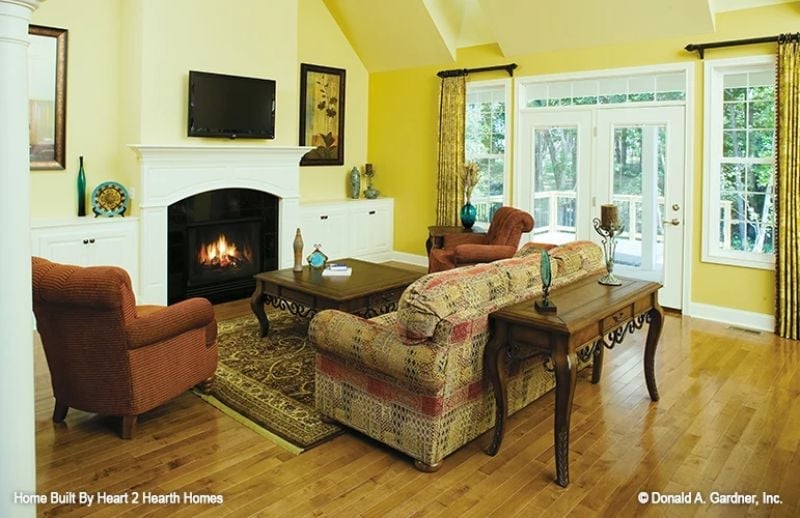 Warm Yellow Walls and a Gas Fireplace Make This Living Room Hard to Leave