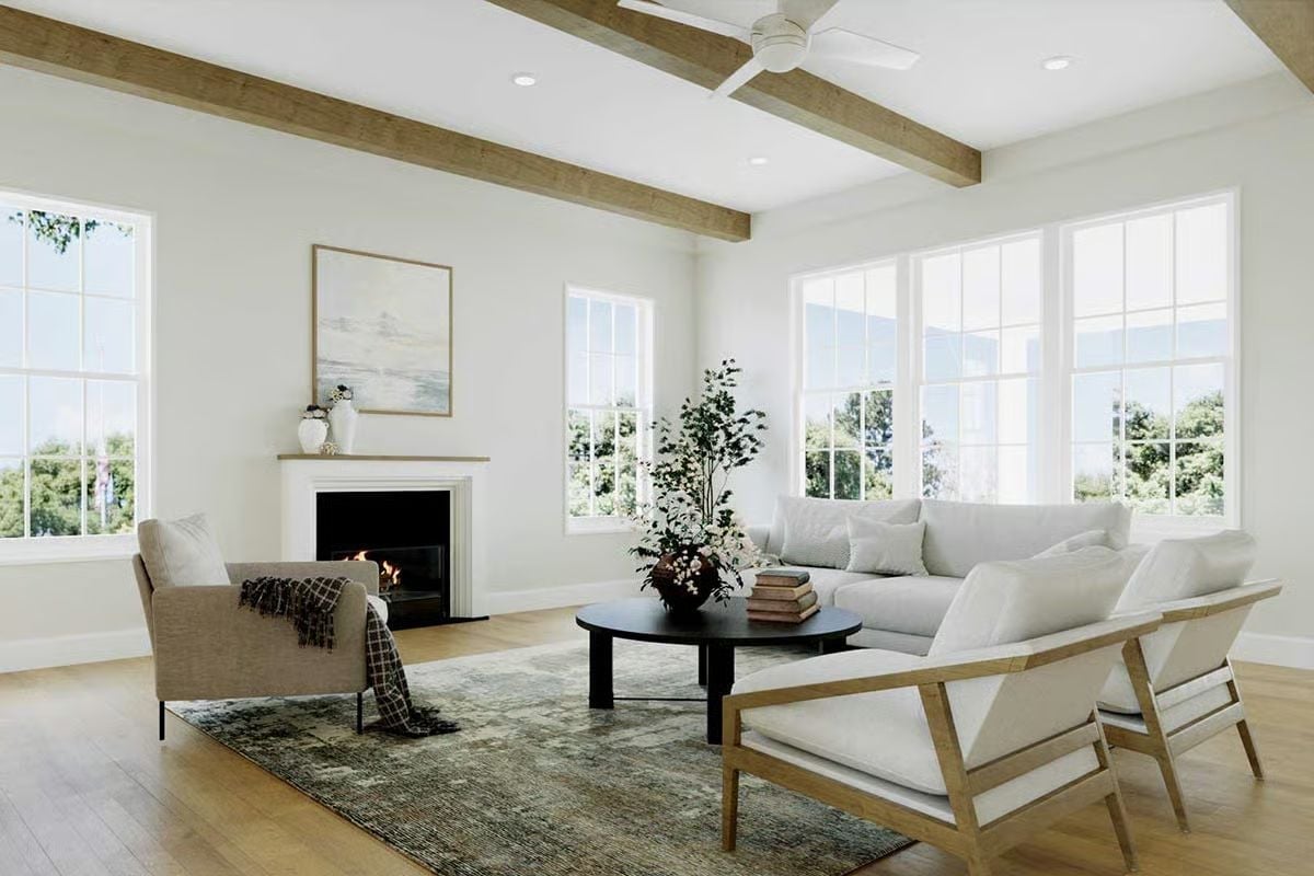 Exposed Beams and a Round Black Table Ground This Living Room Without Crowding It