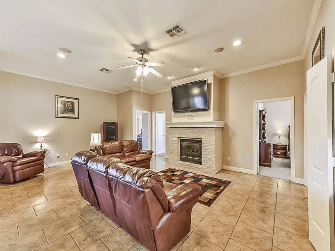 Leather Sectional Country, Stone Fireplace, and a TV That's Earned Its Wall