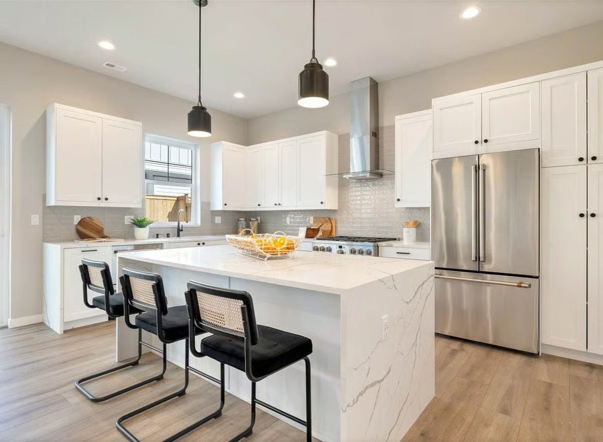 Waterfall Quartz and Rattan Barstools Keep This Kitchen Grounded