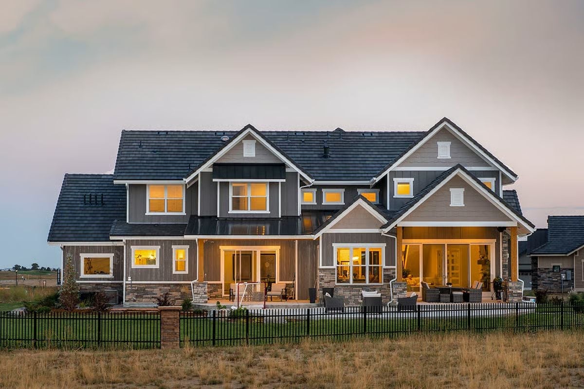 Warm Light Spills Through Every Window at Dusk on This Craftsman Rear Elevation