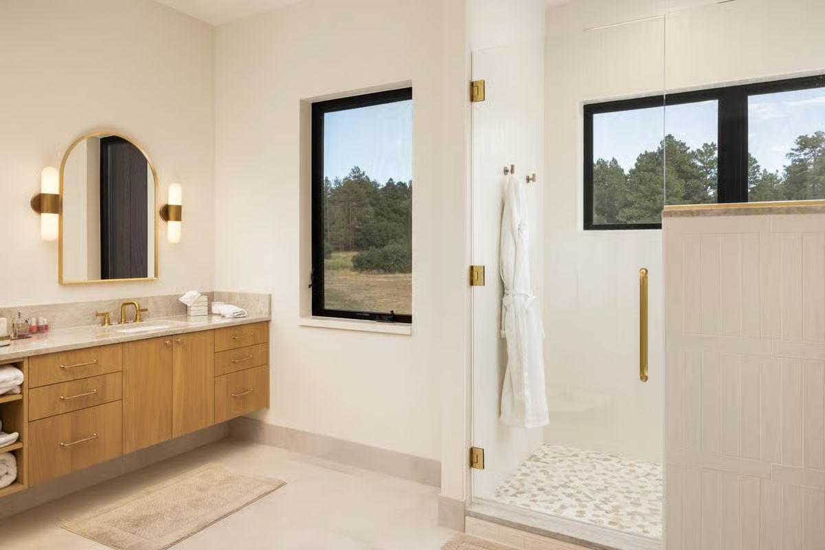 Gold Hardware and Pebble Tile Floor Make a Shower Worth Lingering In