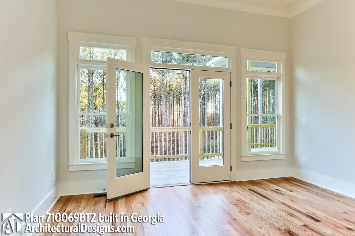 French Doors Onto a Deck With Trees That Close In Around It