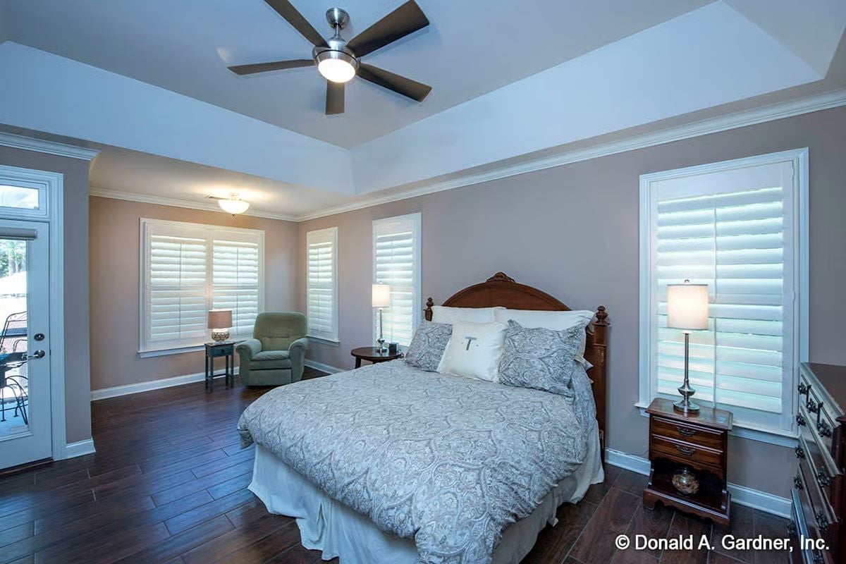 Tray Ceiling and Wood Floors Pull This Master Bedroom Together Without Trying Too Hard