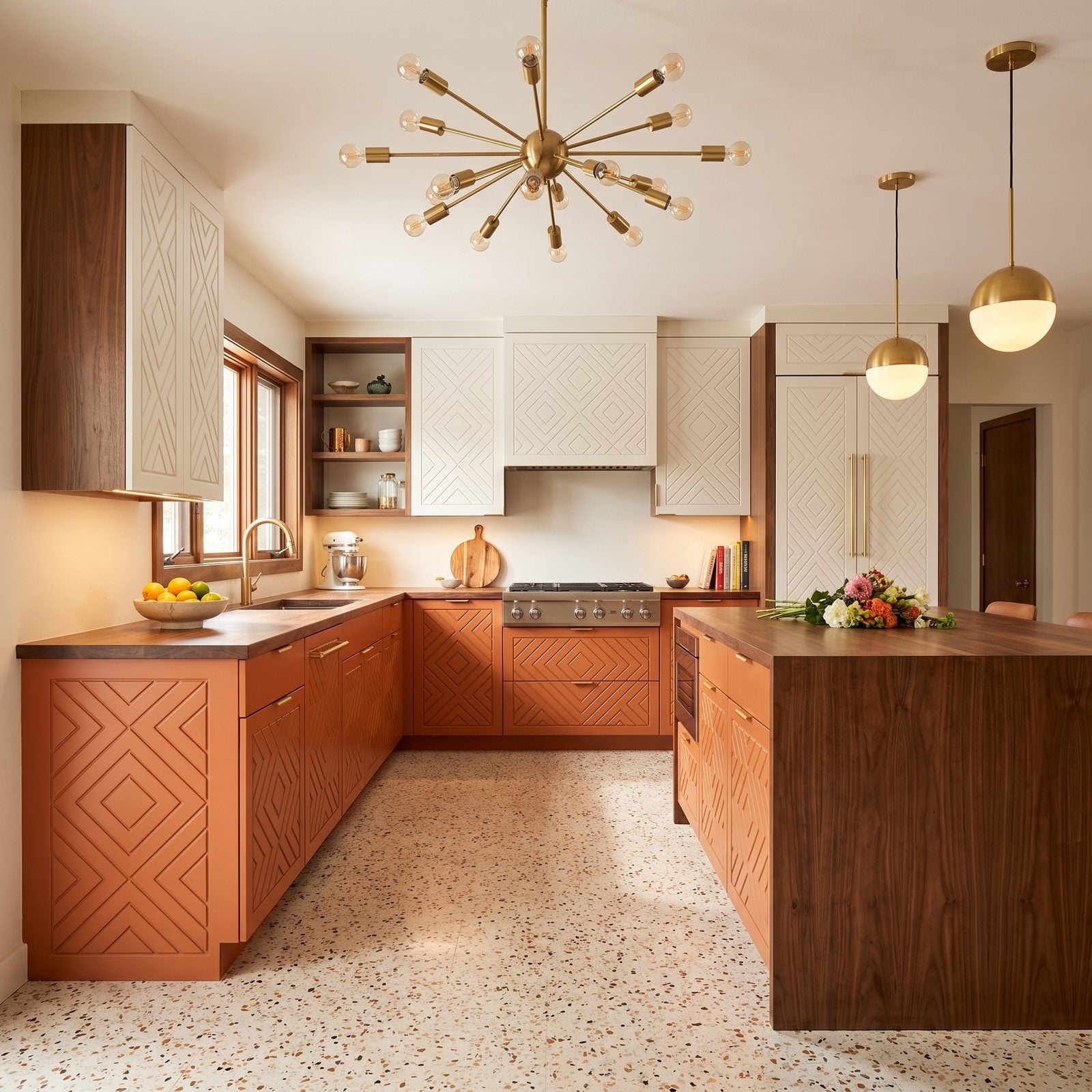 Kitchen with routed geometric panel cabinet doors: Routed diamond-pattern doors in terracotta with walnut and a Sputnik chandelier.
