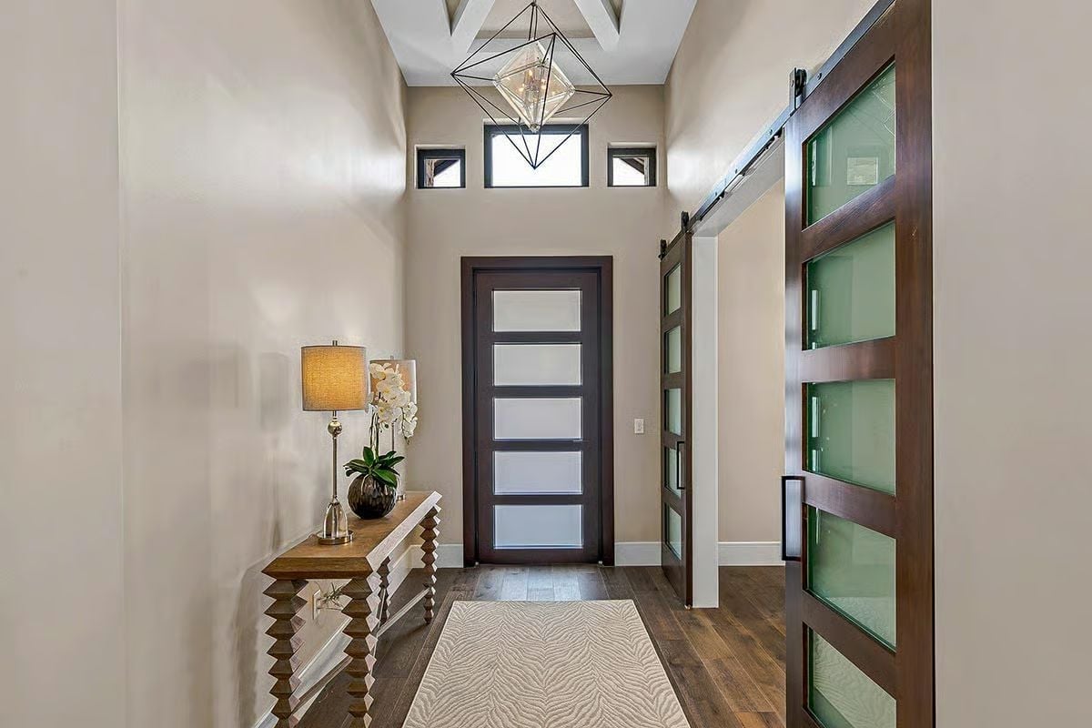 Frosted Glass Barn Door Flanks a Foyer Built for First Impressions
