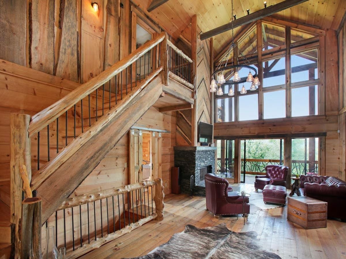 Raw Log Newels and Iron Balusters Give This Staircase Its Character