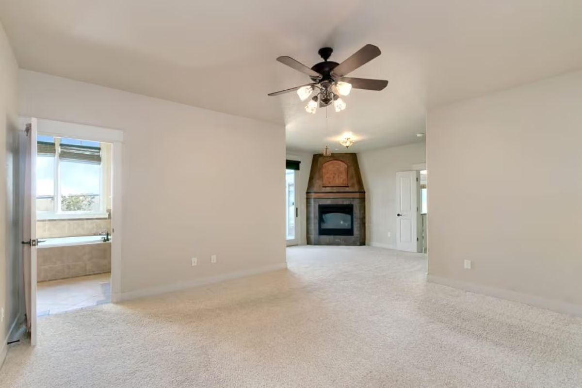 Corner Fireplace and a Ceiling Fan That Pull Double Duty in This Open Suite