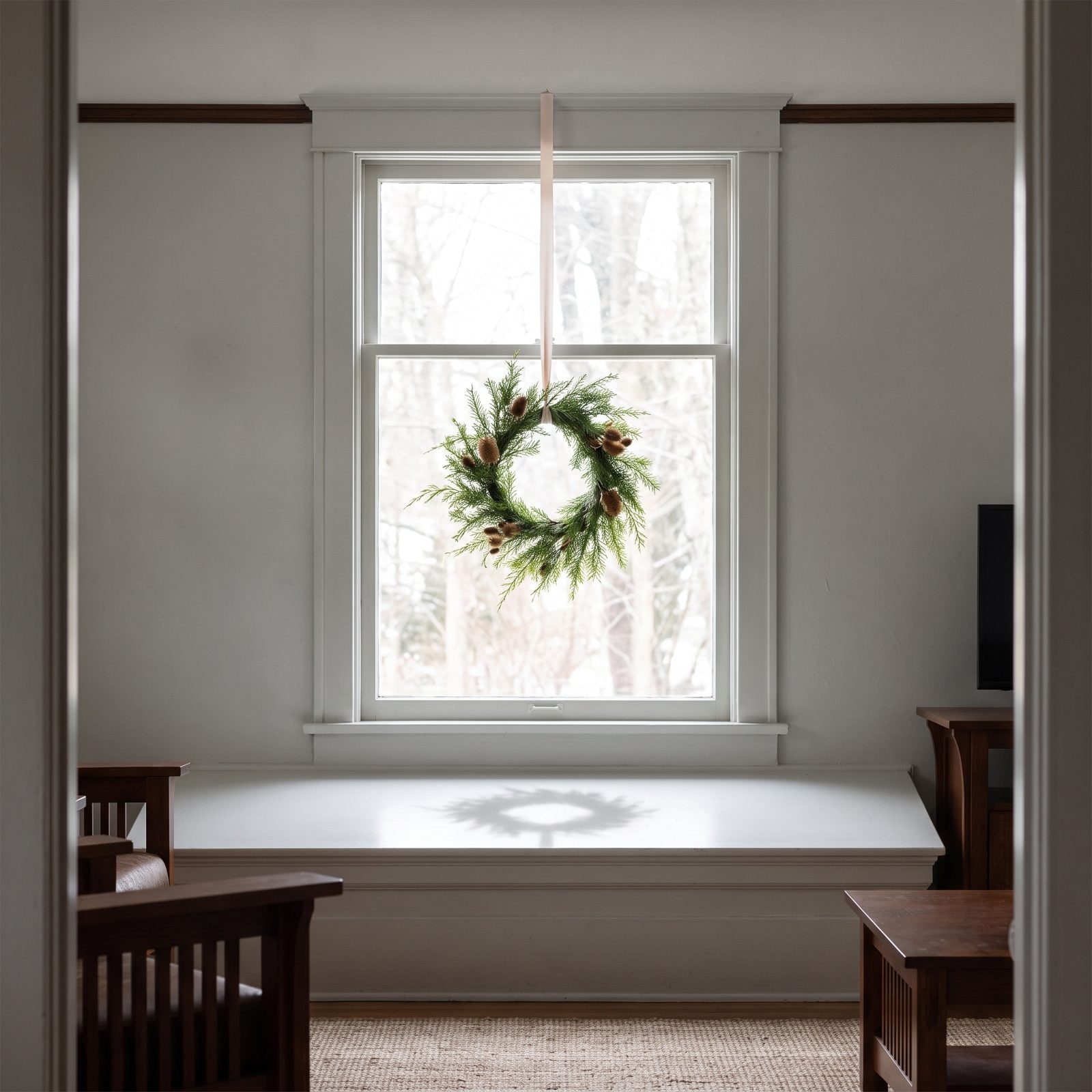 A Single Wreath Suspended in a Bare Window