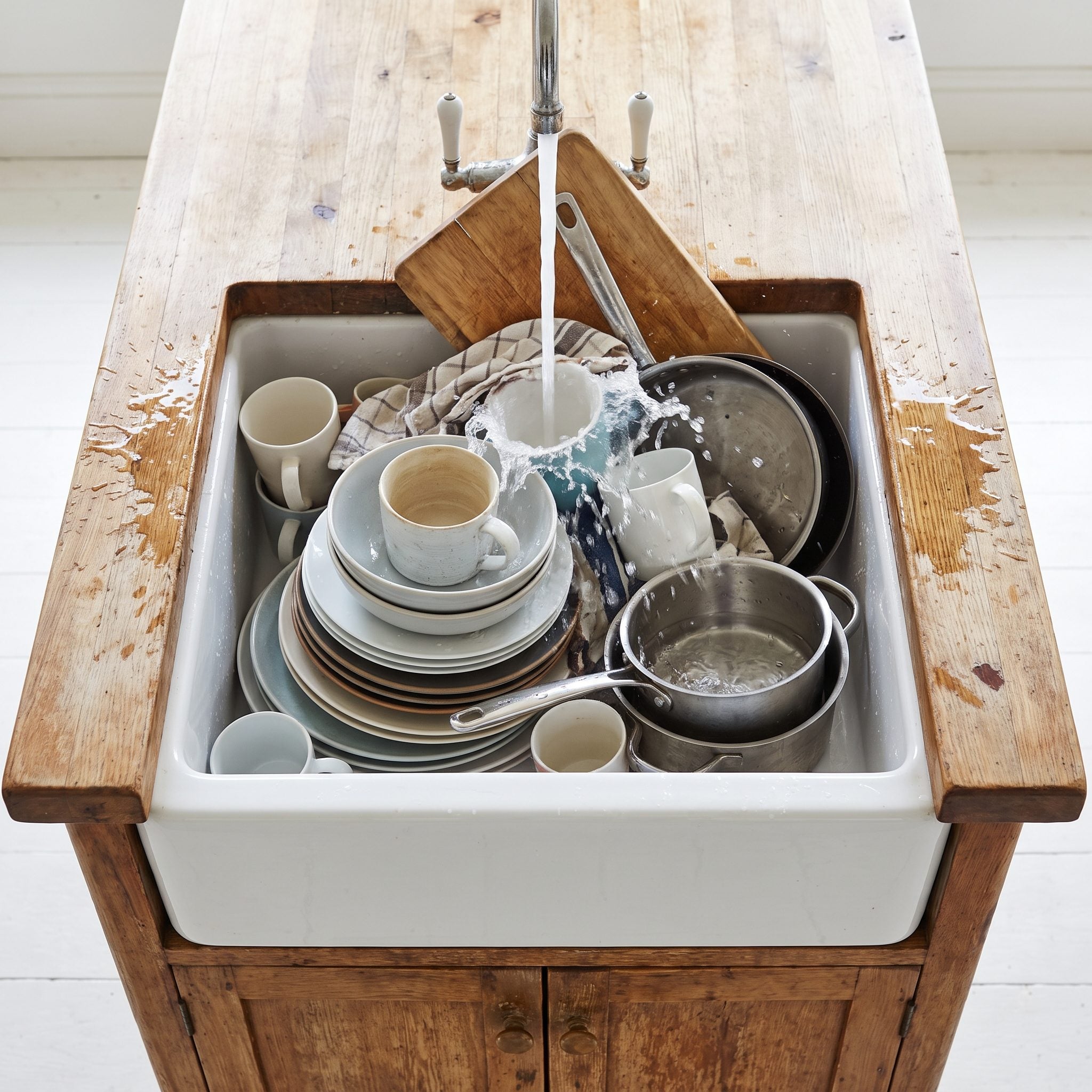White and walnut kitchen with an island sink that has only about 10 inches of counter on each side.