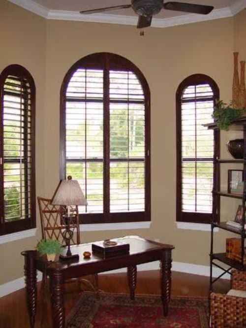 Dark Wood Shutters on Arched Windows Do More Work Than Most People Realize