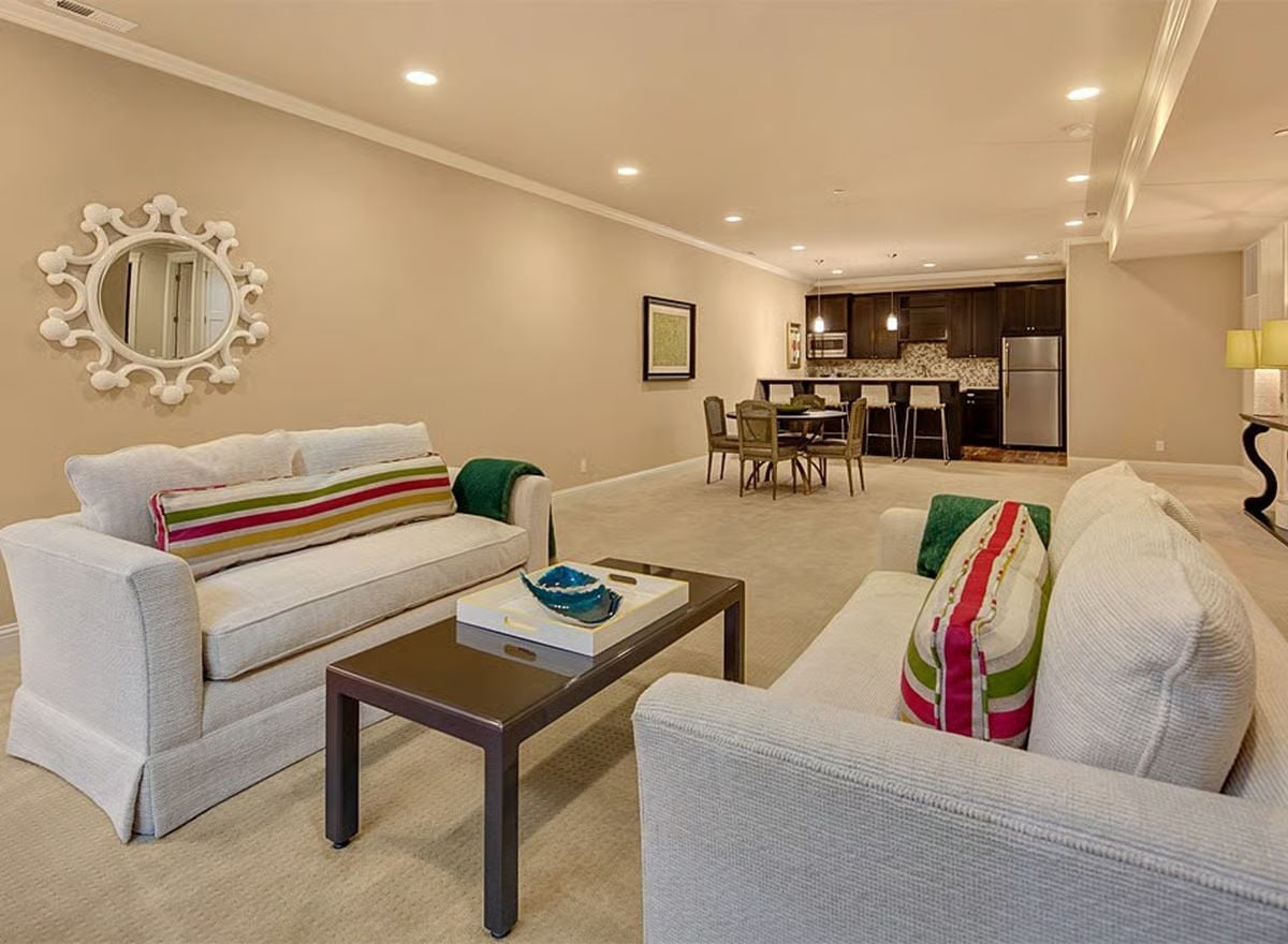 Colorful Stripe Pillows and a Sunburst Mirror Doing Real Work on Beige Walls