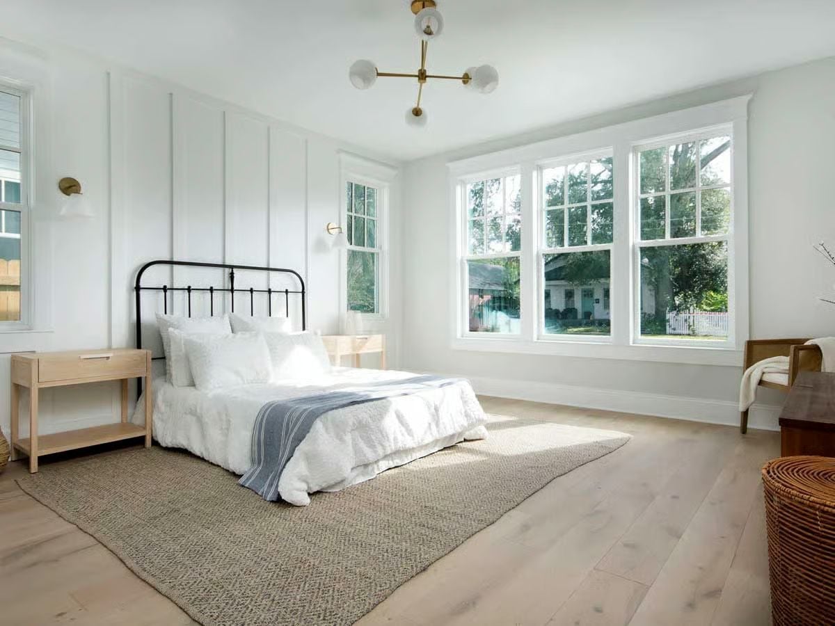Black Iron Headboard and a Seagrass Rug Keep This Primary Bedroom Grounded