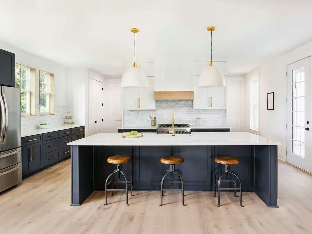 Navy Island Base and Warm Wood Stools Push Back Against All-White Kitchen Fatigue