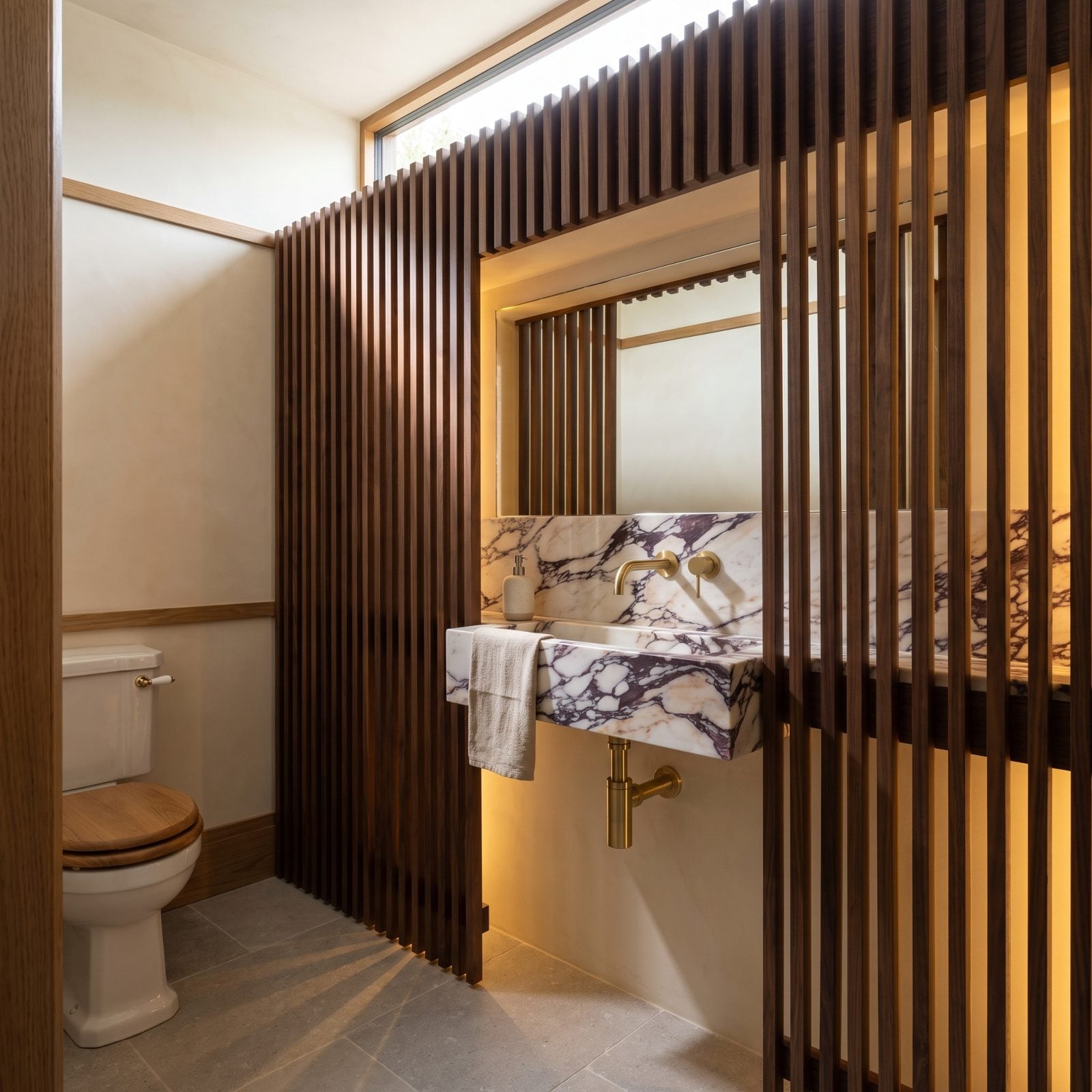 A Walnut Slat Screen Hiding the Marble Hand-Wash Zone