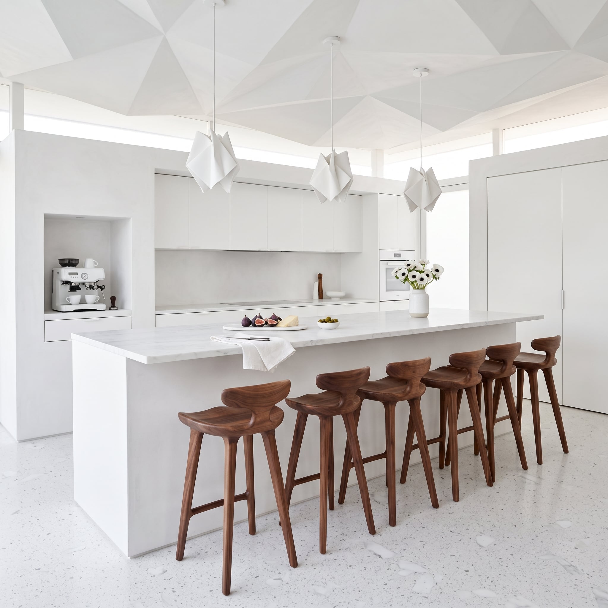 Five Walnut Barstools Lined Up Against White Marble Prove Repetition Is a Design Decision