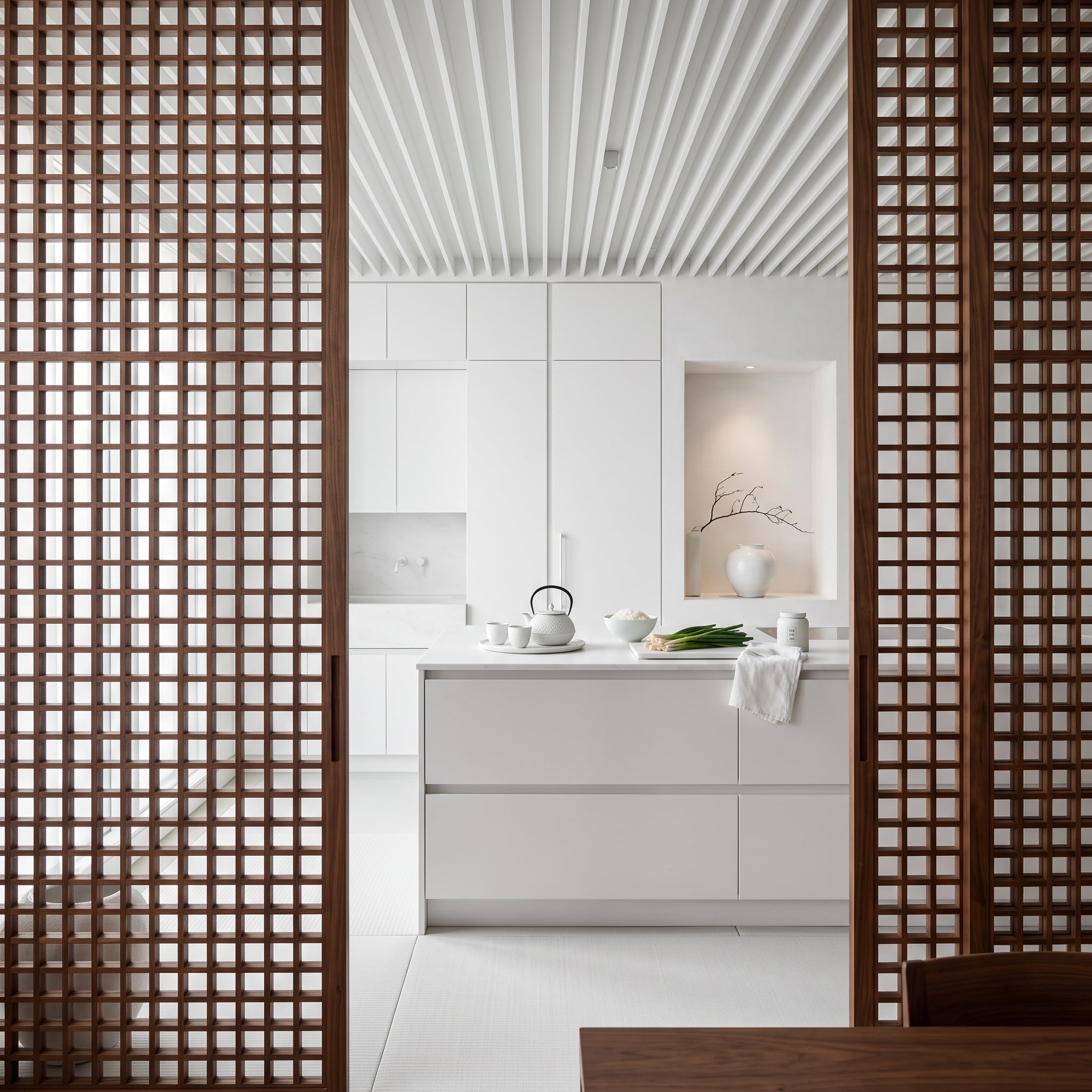 Walnut Lattice Screens Framing a White Kitchen Prove the Doorway Is the Design