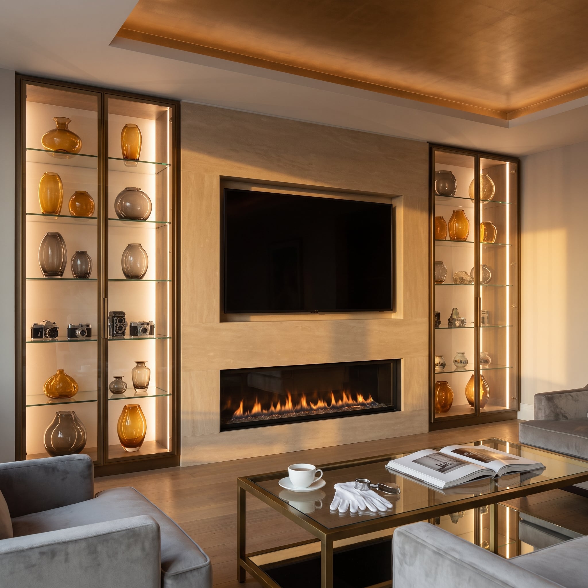 Living room with recessed television above linear fireplace and tall illuminated bronze-framed glass display cabinets