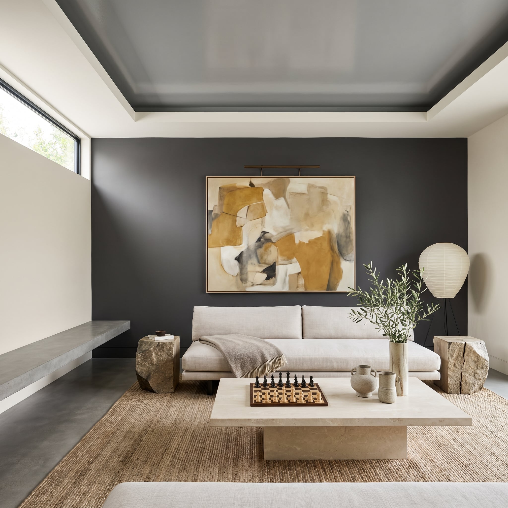 Charcoal plaster living room accent wall with illuminated abstract painting and pale linen sofa
