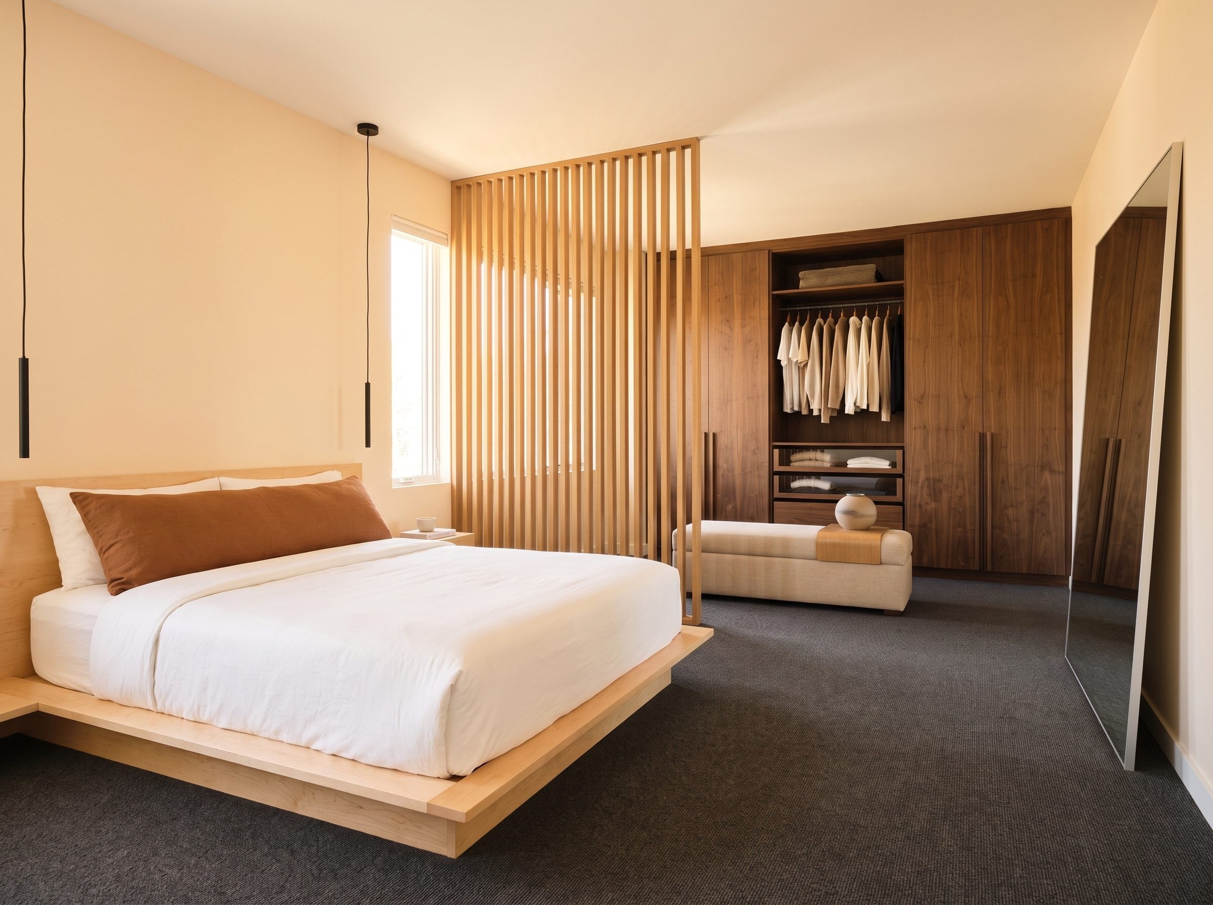 Bedroom with pale maple platform bed, dark walnut wardrobe, and slatted oak room divider