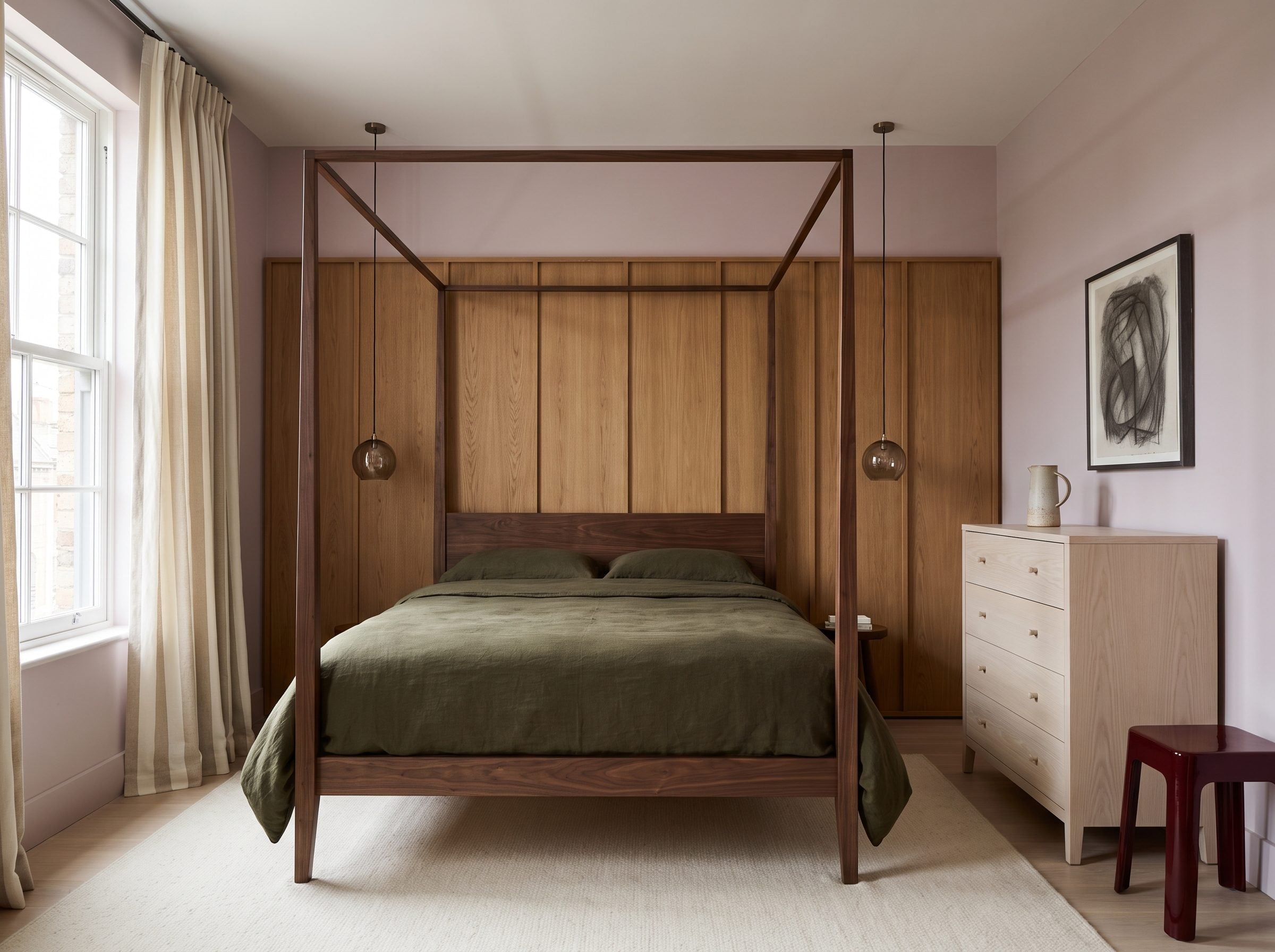 Bedroom with dark walnut four-poster bed, oak wall paneling, bleached dresser, and olive bedding