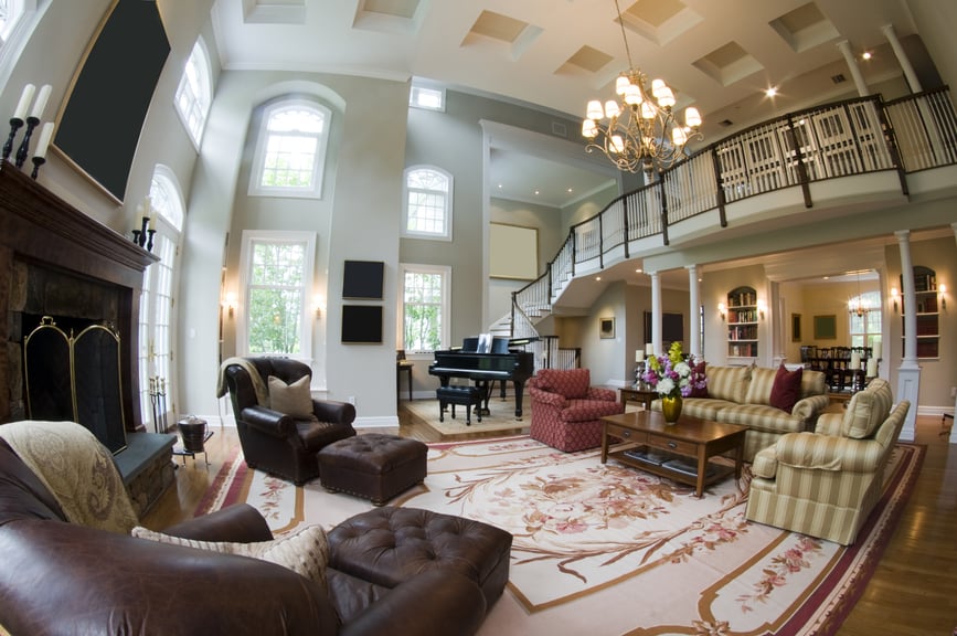 Huge living room with grand piano, large rug, huge fireplace and separate sitting area